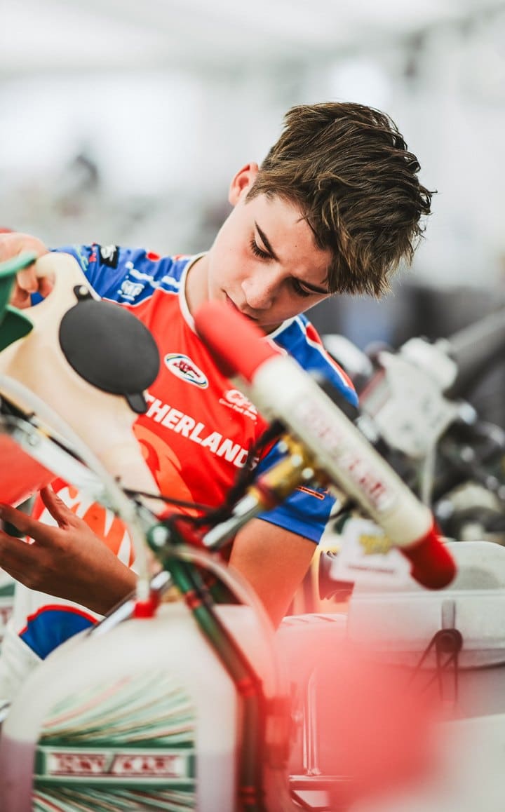 Mees als jonge karter met helm en handschoenen